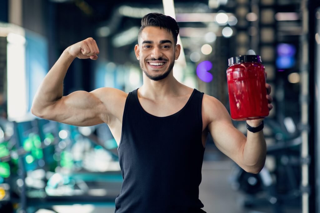 suplementos de creatina, hombre mostrando sus musculos sonriente