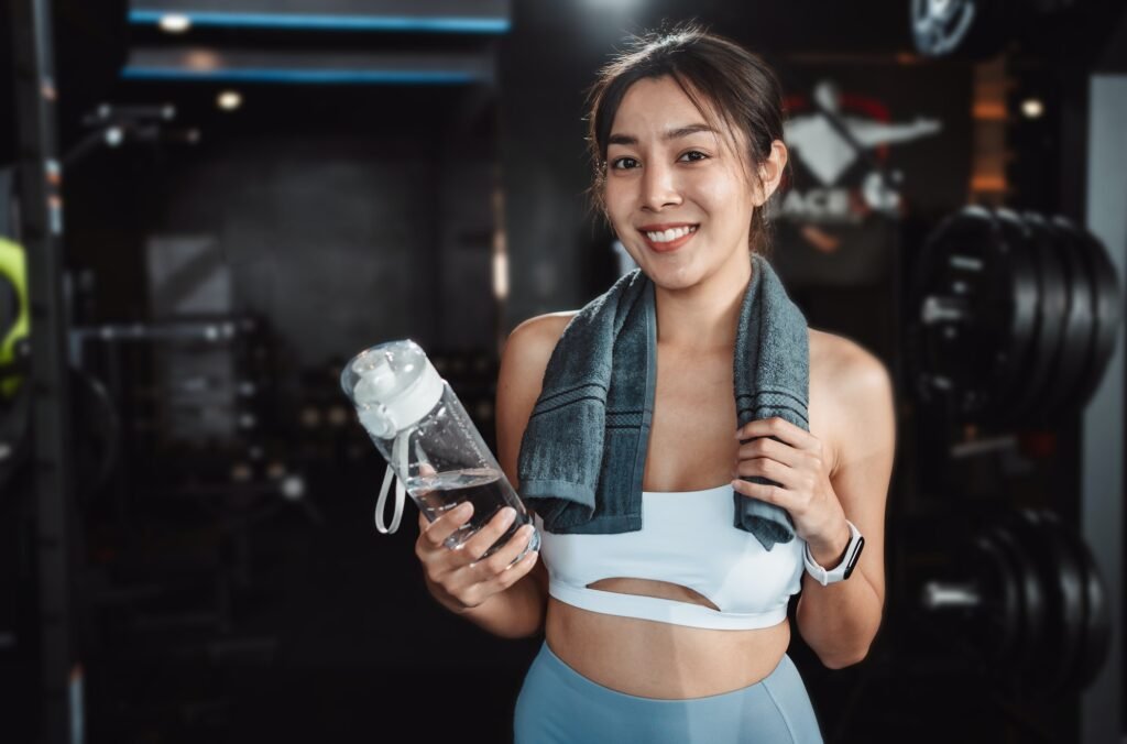 recuperación post-entrenamiento, mujer bebiendo aguya despues de entreanar