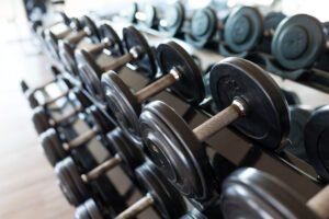 Cómo Potenciar el Desarrollo Muscular. mancuernas en el gimnasio