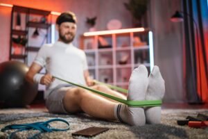 Man doing exercises with resistance band on floor